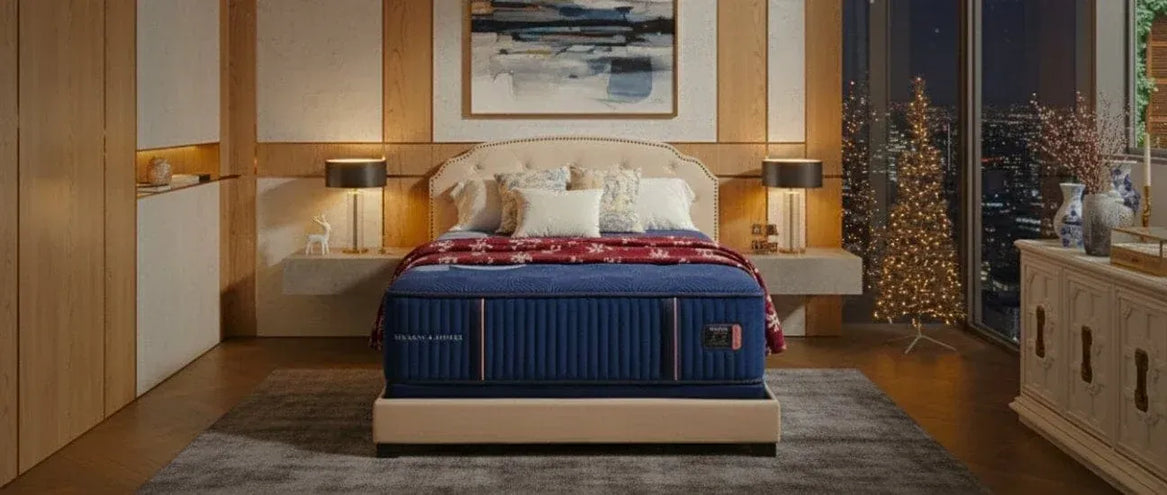 Blue and beige bed with Stearns & Foster mattress from Sleepology in a bedroom setting with decorative elements.